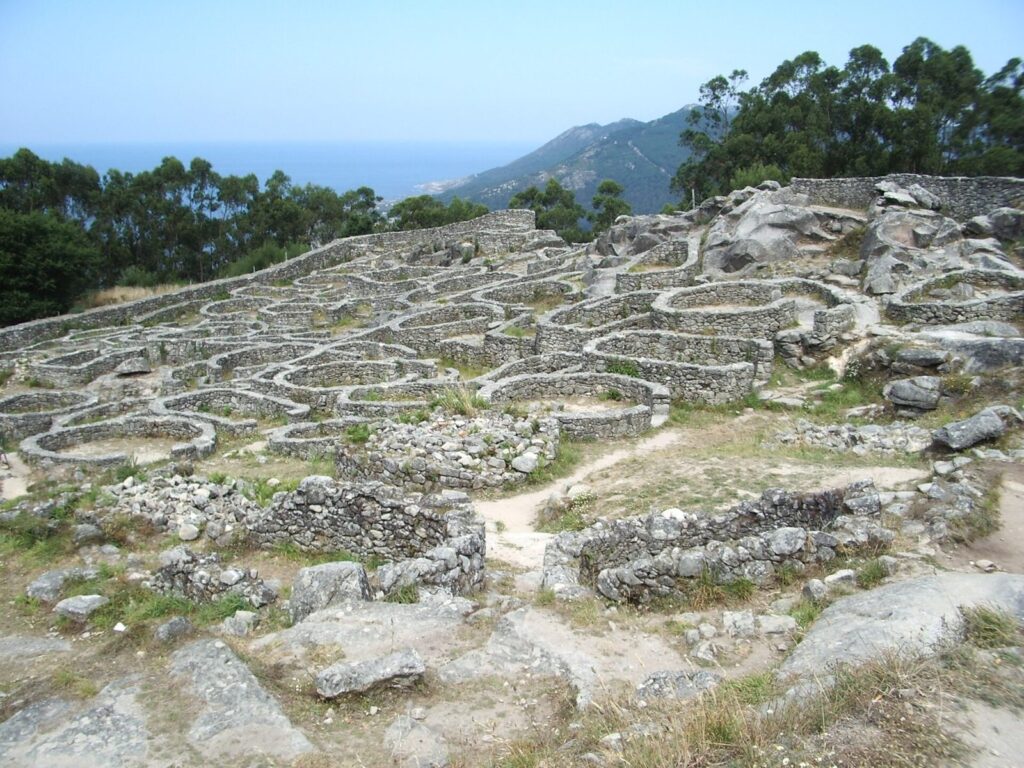Vista del Castro de Santa Tegra en A Guarda, Pontevedra, con casas circulares de piedra reconstruidas y vista al mar